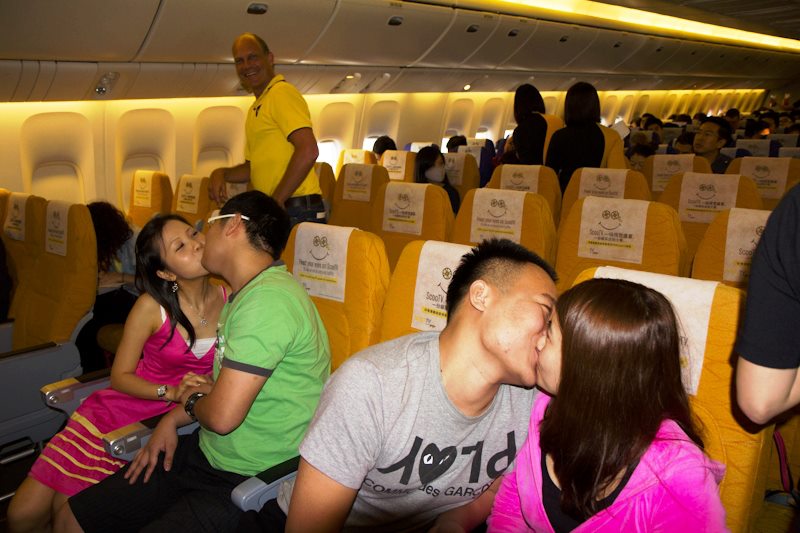 FLY ME TO THE MOON: Kyssegalde asiatiske par sjekket inn på Scoot-flyvningen i håp om å vinne en gratis ferietur. Og det gjorde de - alle sammen. Foto: Scoots Facebook-side